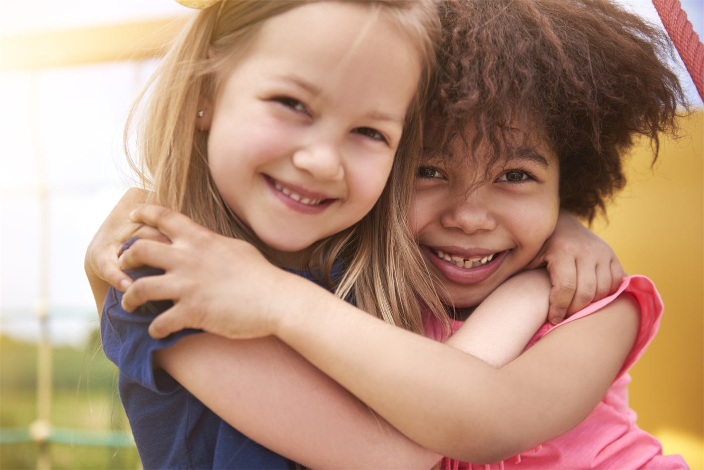 Two smiling kids hugging