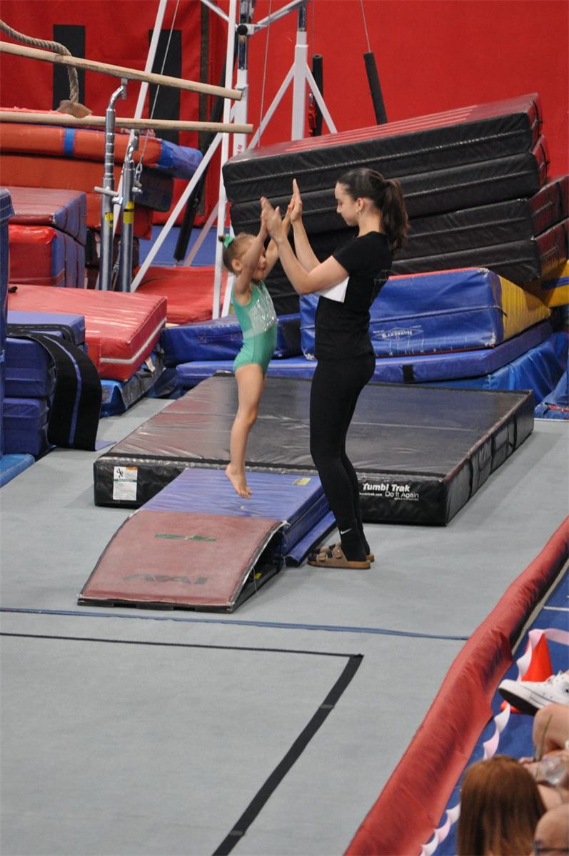 Black Diamond coach spotting a young gymnast in the gym