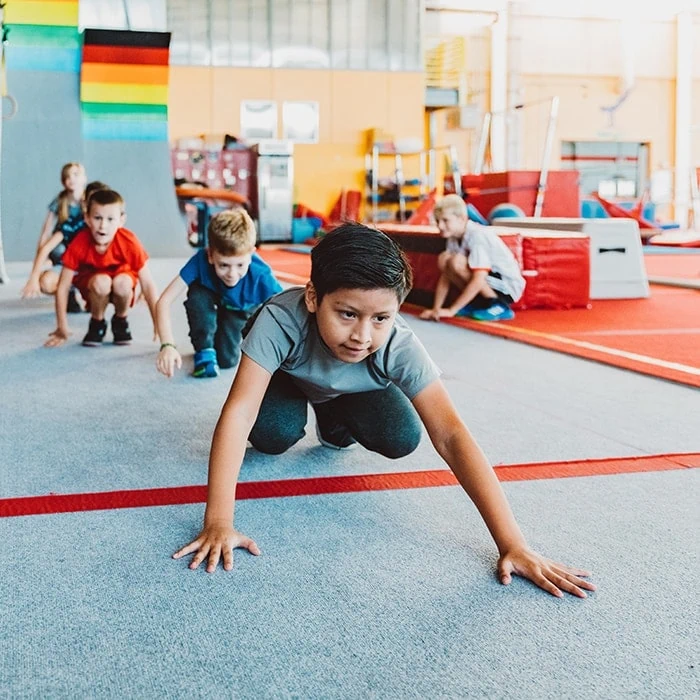 Dragon Ninja students crawling through an obstacle course