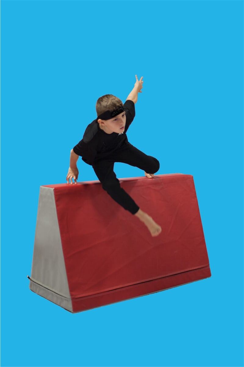 Boy vaulting over a padded block