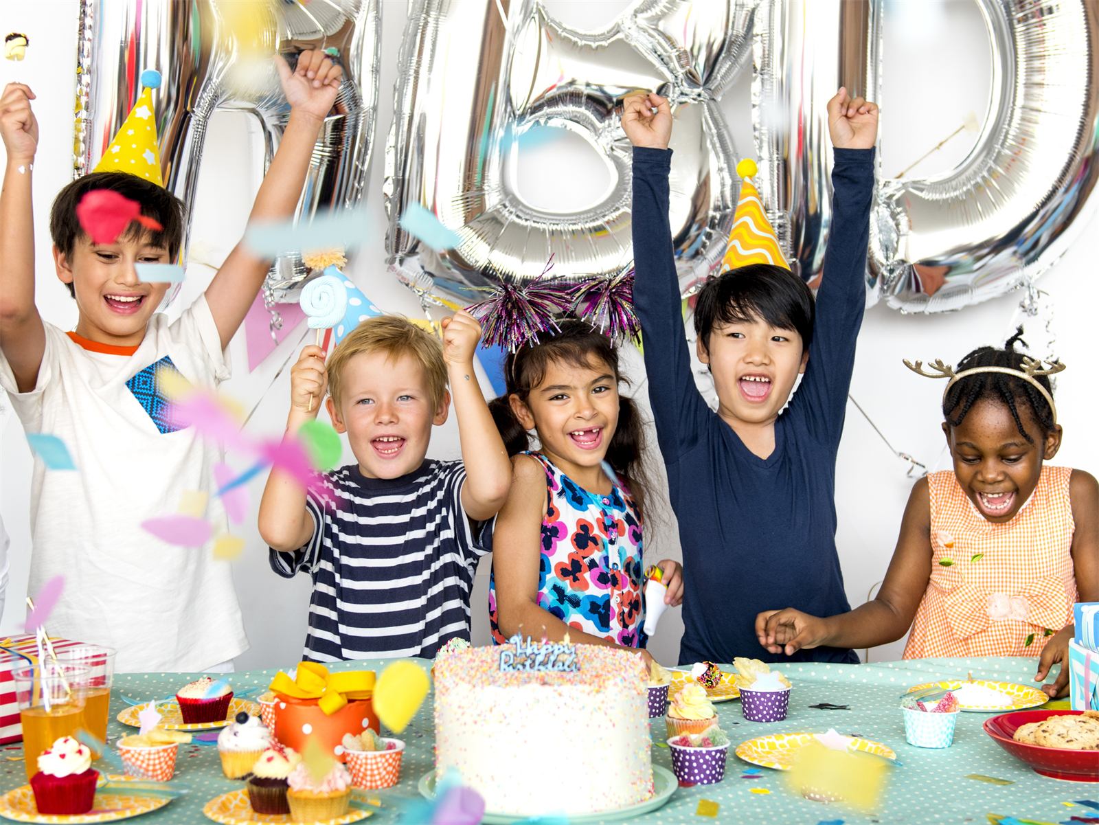Kids cheering at a birthday party table