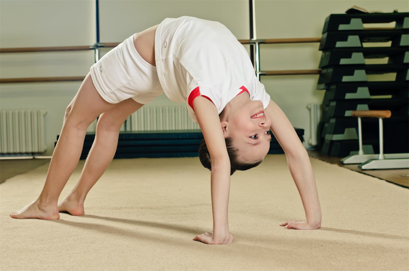 Child holding a bridge on a mat